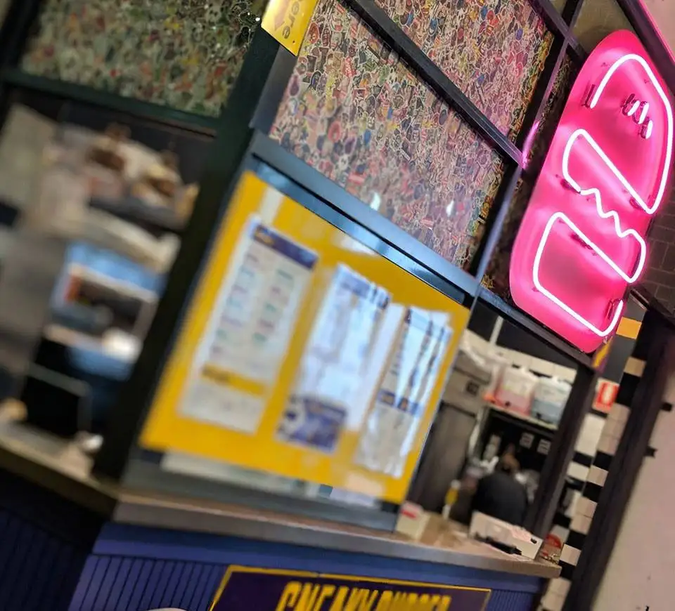 Sneaky Burger shop interior glowing under the neon sign